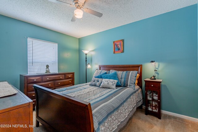 bedroom featuring ceiling fan, a textured ceiling, and carpet floors