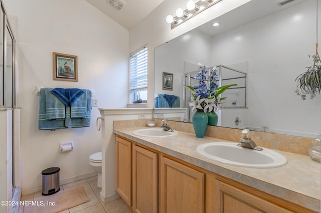 bathroom featuring tile flooring, dual vanity, walk in shower, lofted ceiling, and toilet