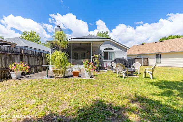 rear view of house with a patio area, an outdoor fire pit, and a lawn