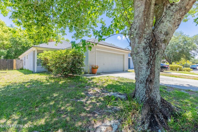 obstructed view of property with a front yard and a garage