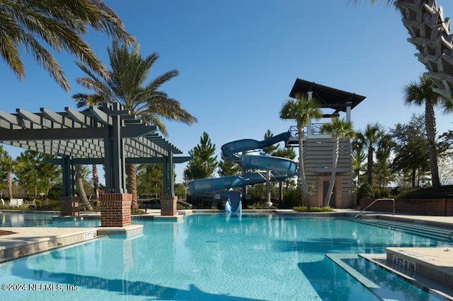 community pool with a pergola and a water slide