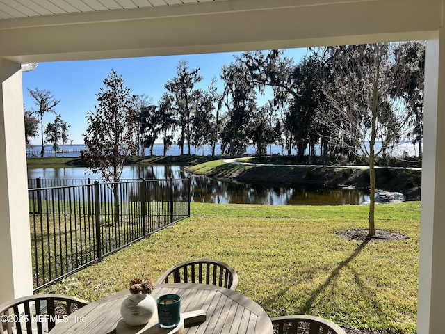 view of yard featuring a water view and fence