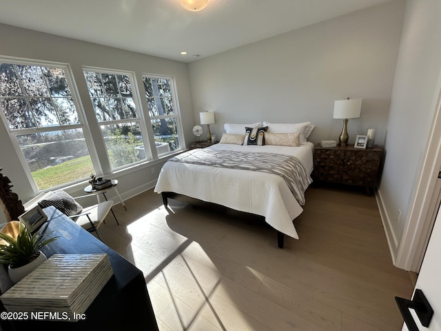 bedroom with recessed lighting, baseboards, and wood finished floors