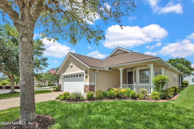 view of front of property with a garage, covered porch, and a front yard