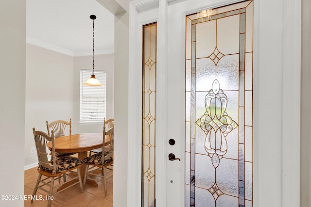 entryway with ornamental molding and light tile patterned flooring