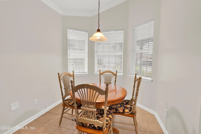 tiled dining room featuring plenty of natural light, lofted ceiling, and ornamental molding