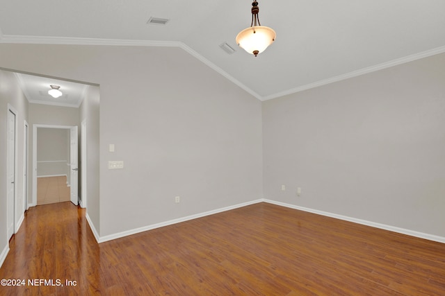 empty room with lofted ceiling, dark wood-type flooring, and ornamental molding