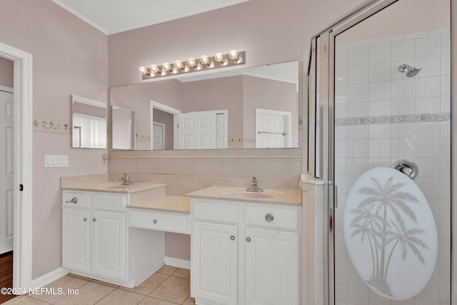 bathroom with tile patterned floors, vanity, a shower with door, and ornamental molding