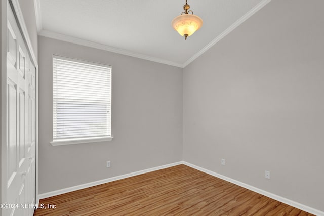 spare room with hardwood / wood-style floors, a healthy amount of sunlight, and ornamental molding