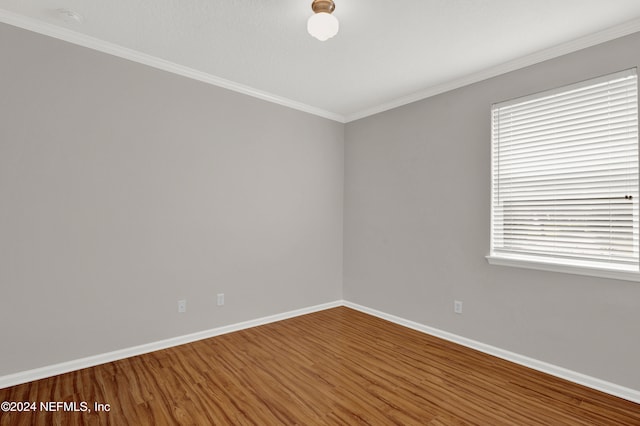 unfurnished room with a wealth of natural light, crown molding, and hardwood / wood-style flooring