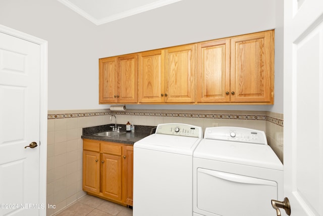 laundry room with cabinets, sink, independent washer and dryer, light tile patterned floors, and tile walls