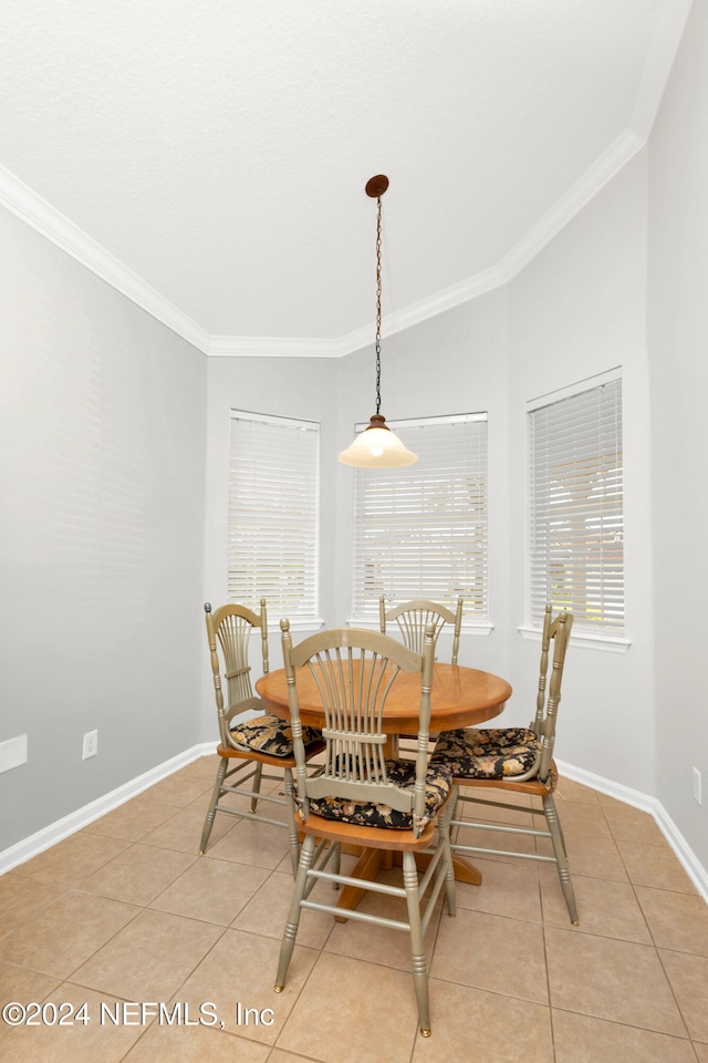 dining area featuring light tile patterned flooring, a healthy amount of sunlight, and ornamental molding