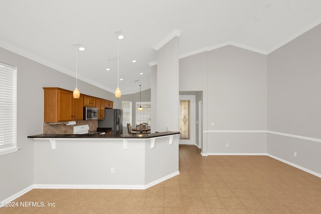 kitchen with kitchen peninsula, ornamental molding, stainless steel appliances, vaulted ceiling, and hanging light fixtures