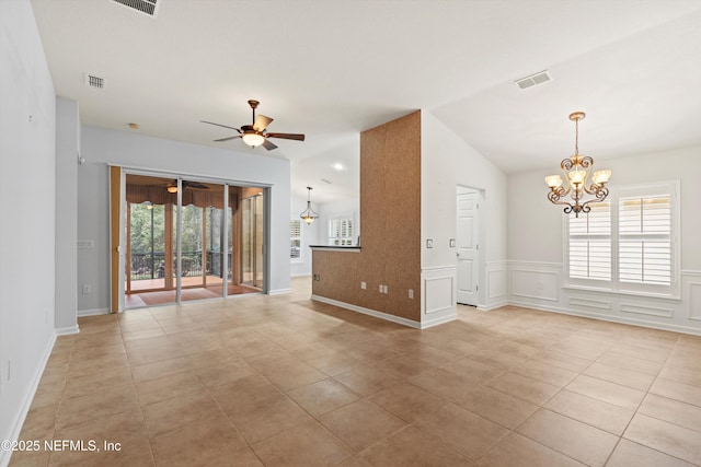 tiled spare room featuring lofted ceiling and ceiling fan with notable chandelier