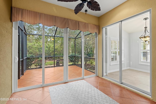 doorway featuring tile patterned flooring and ceiling fan