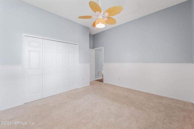 unfurnished bedroom with a closet, ceiling fan, and light colored carpet