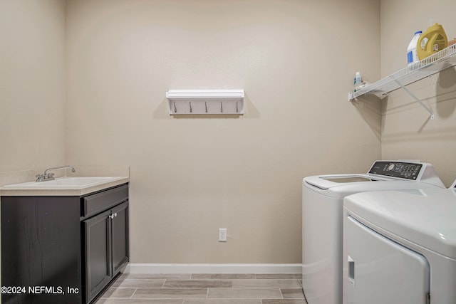 laundry room with cabinets, separate washer and dryer, light hardwood / wood-style flooring, and sink