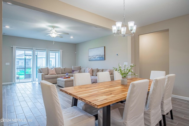 dining space with hardwood / wood-style flooring and ceiling fan with notable chandelier