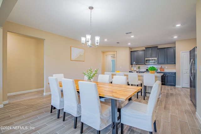 dining room featuring a notable chandelier and light wood-type flooring