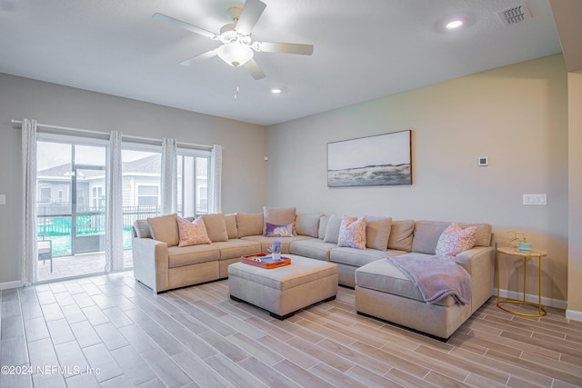 living room with light hardwood / wood-style flooring and ceiling fan