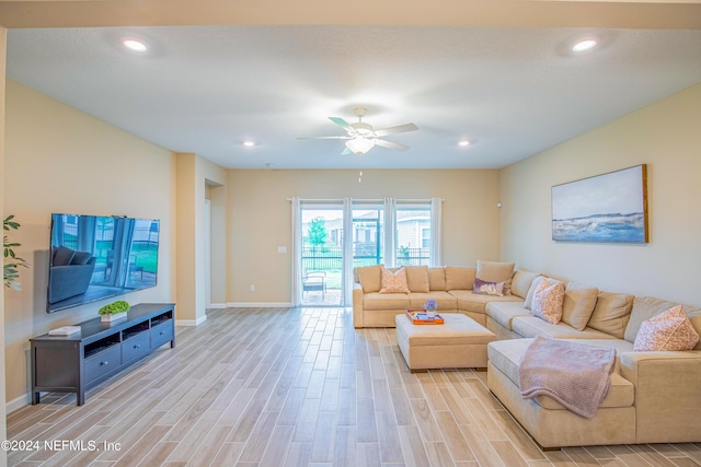 living room featuring ceiling fan and light hardwood / wood-style floors