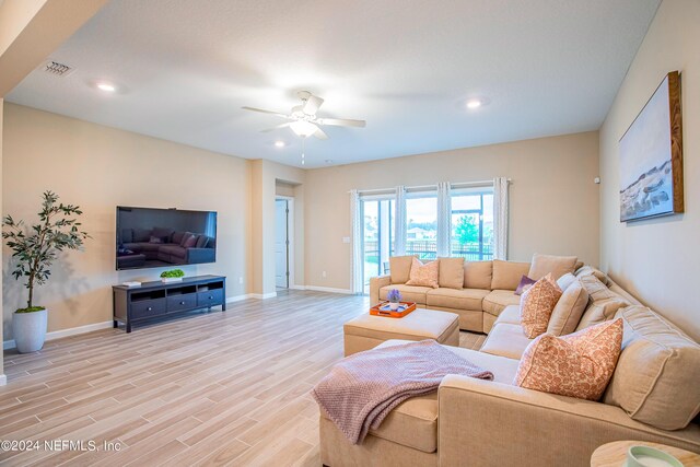 living room featuring ceiling fan and light hardwood / wood-style flooring