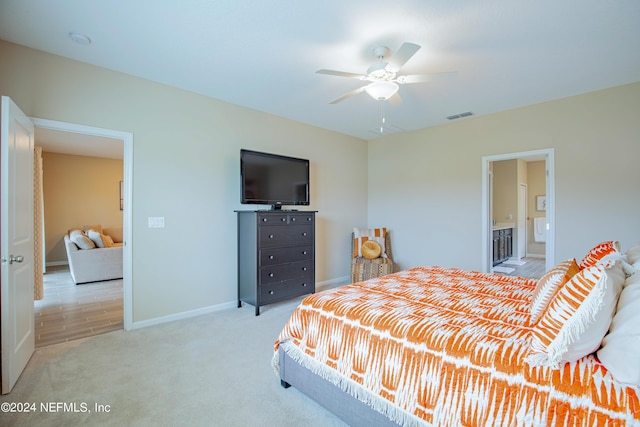 carpeted bedroom featuring ensuite bath and ceiling fan