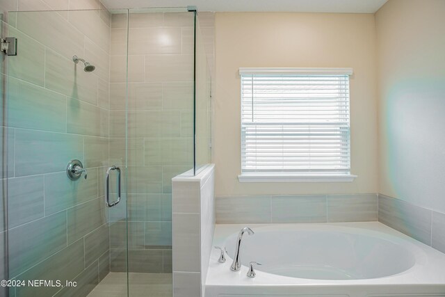 bathroom featuring independent shower and bath