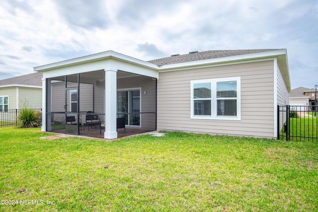 back of house with a lawn and a sunroom