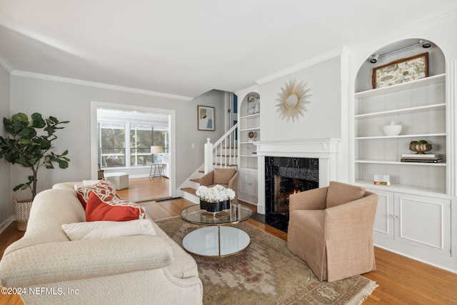 living room with a fireplace, crown molding, and hardwood / wood-style floors