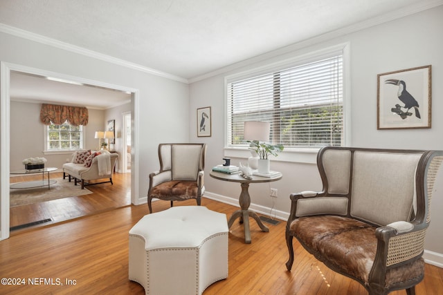 sitting room featuring light hardwood / wood-style floors and crown molding