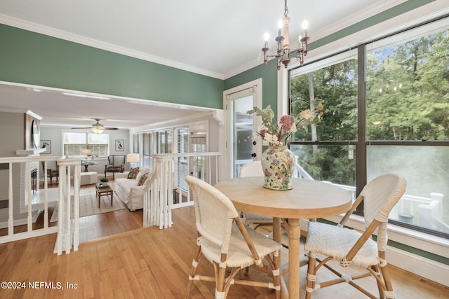 dining area featuring hardwood / wood-style floors, ceiling fan with notable chandelier, and crown molding