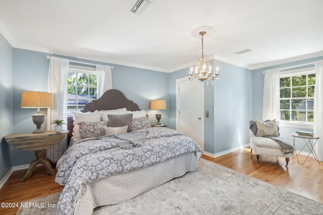 bedroom with a notable chandelier, wood-type flooring, and crown molding