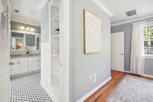 bathroom featuring crown molding, vanity, and wood-type flooring