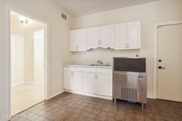 kitchen featuring white cabinetry, sink, and tile patterned flooring