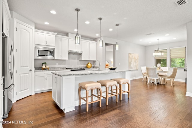 kitchen featuring white cabinetry, appliances with stainless steel finishes, and a center island with sink