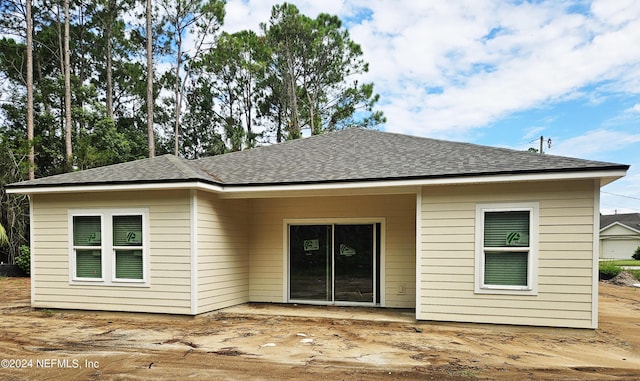 rear view of property featuring a shingled roof