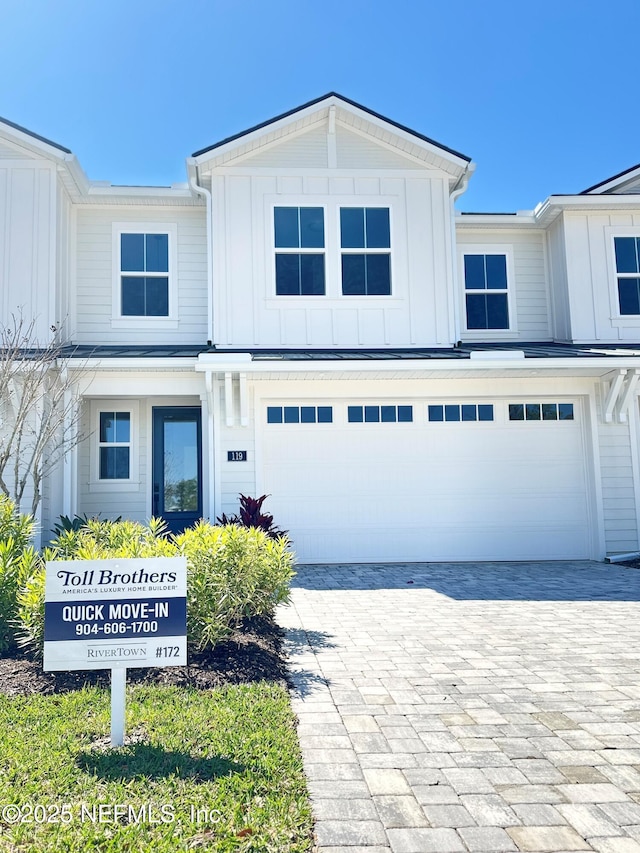 view of front of house featuring decorative driveway, board and batten siding, and an attached garage