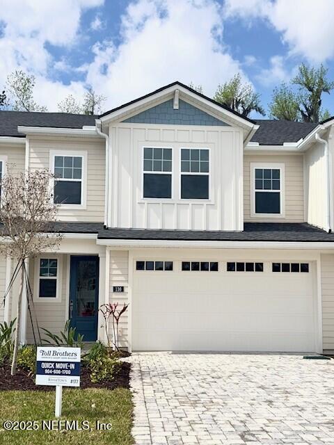 view of front of home featuring board and batten siding, decorative driveway, and a garage