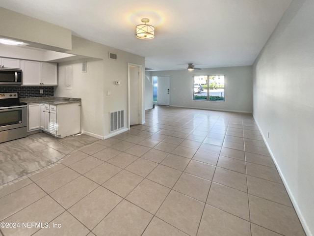 kitchen with backsplash, ceiling fan, stainless steel appliances, light tile flooring, and white cabinets