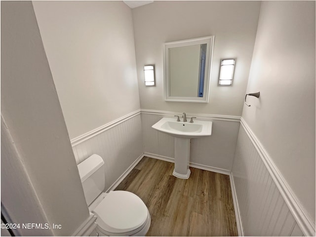 bathroom featuring wood-type flooring and toilet