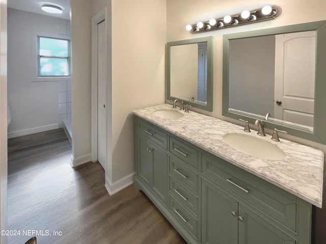 bathroom with hardwood / wood-style flooring and dual vanity