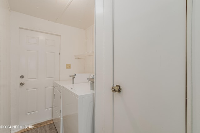 laundry area featuring wood-type flooring and separate washer and dryer