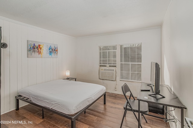 bedroom with a textured ceiling, ornamental molding, and wood-type flooring