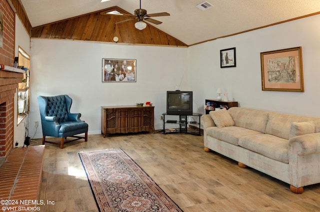 living room featuring brick wall, a fireplace, hardwood / wood-style flooring, ceiling fan, and a textured ceiling