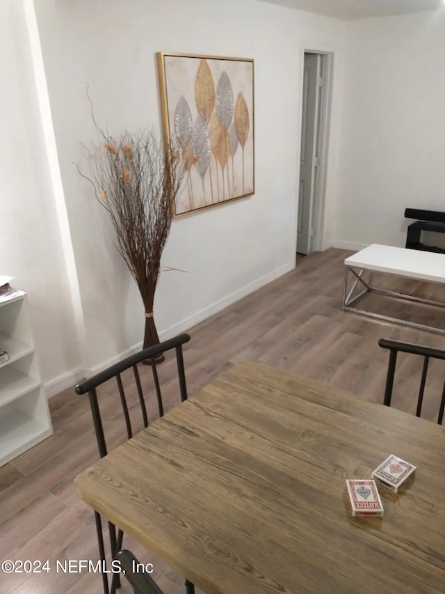 dining space with wood-type flooring