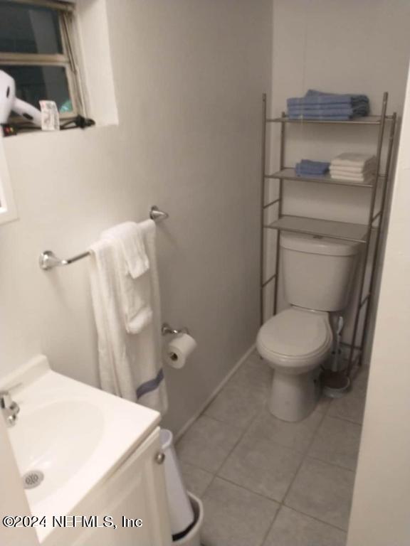 bathroom with tile floors, toilet, and vanity