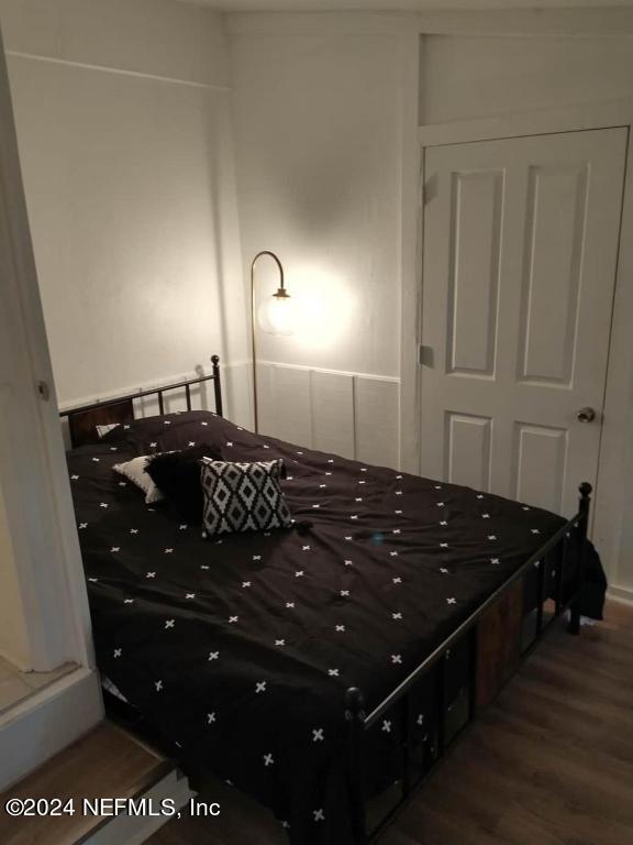 bedroom with dark hardwood / wood-style flooring and a closet