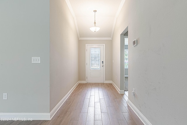 entryway with ornamental molding and hardwood / wood-style floors