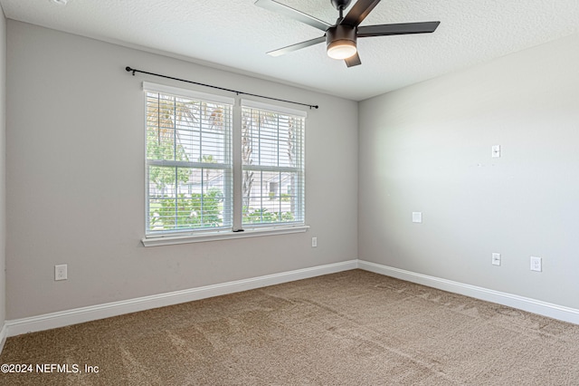 carpeted spare room with ceiling fan and a textured ceiling